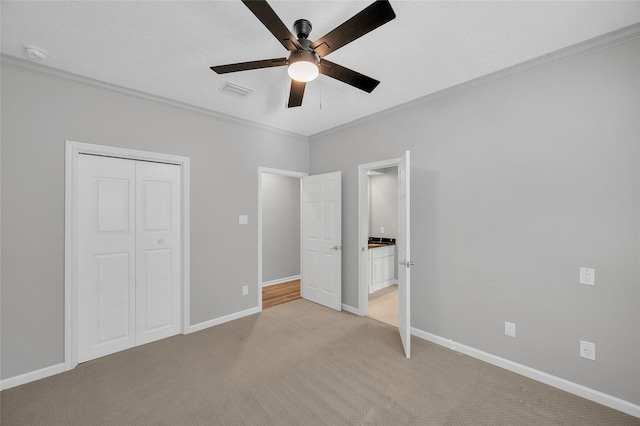 unfurnished bedroom with a closet, ornamental molding, a ceiling fan, light carpet, and baseboards