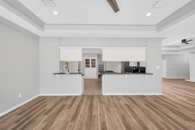 kitchen featuring a peninsula, visible vents, and white cabinets