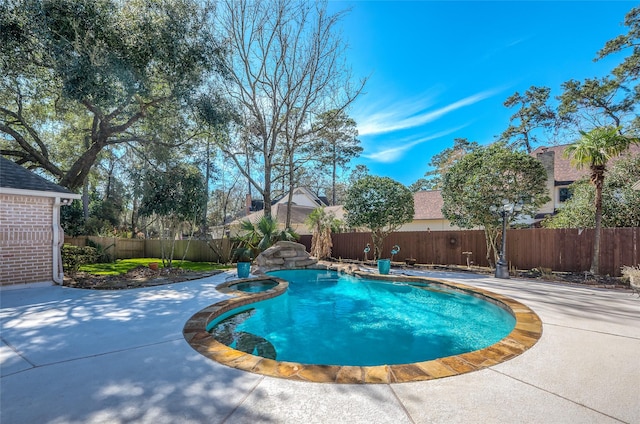 view of pool featuring a pool with connected hot tub, a fenced backyard, and a patio