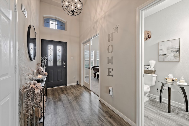 foyer featuring hardwood / wood-style flooring, a healthy amount of sunlight, and a notable chandelier