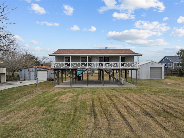 back of house with a garage, an outdoor structure, a yard, and a patio area