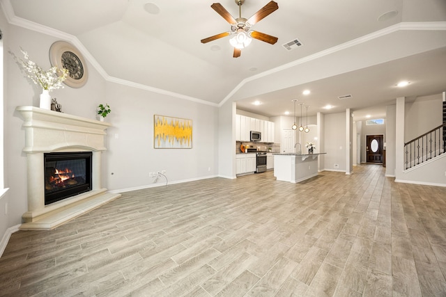 unfurnished living room with crown molding, vaulted ceiling, and light hardwood / wood-style floors