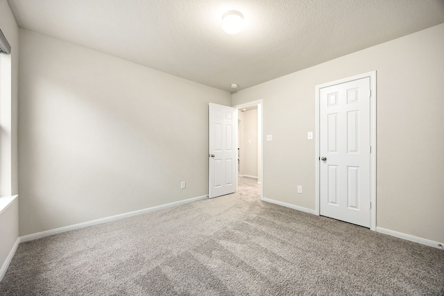 unfurnished bedroom featuring a textured ceiling and carpet