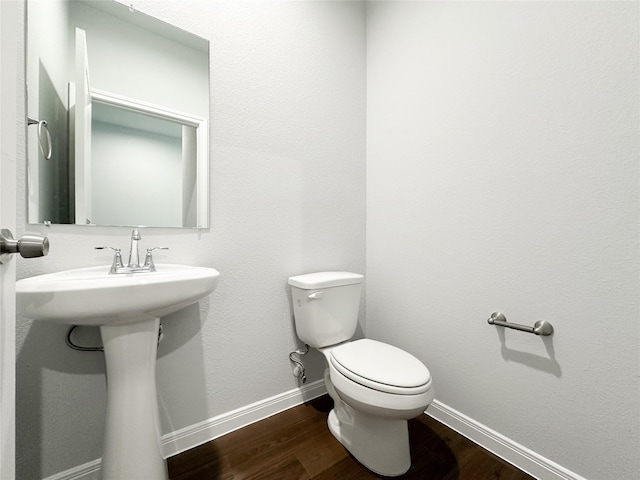 bathroom with wood-type flooring and toilet