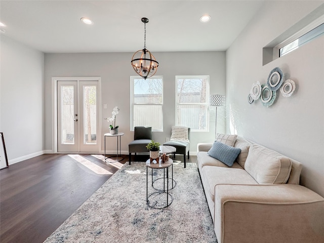 living room featuring hardwood / wood-style flooring, an inviting chandelier, and french doors