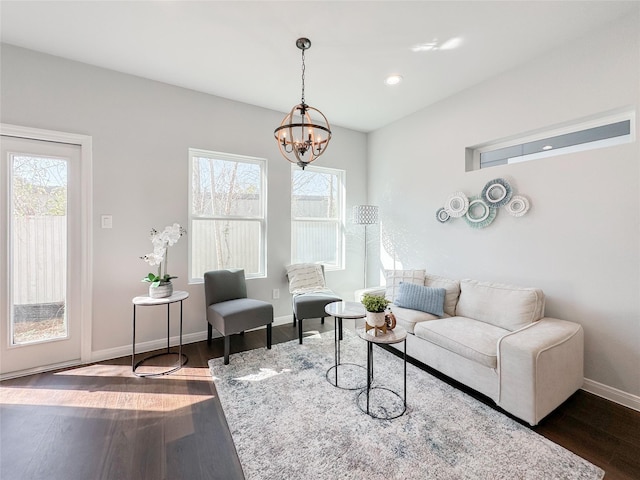 living room with dark wood-type flooring and a chandelier