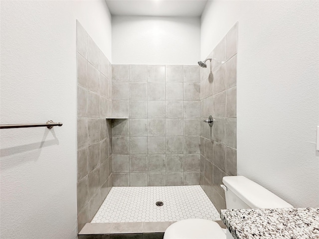 bathroom featuring toilet and tiled shower