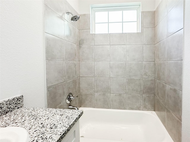 bathroom with vanity and tiled shower / bath combo