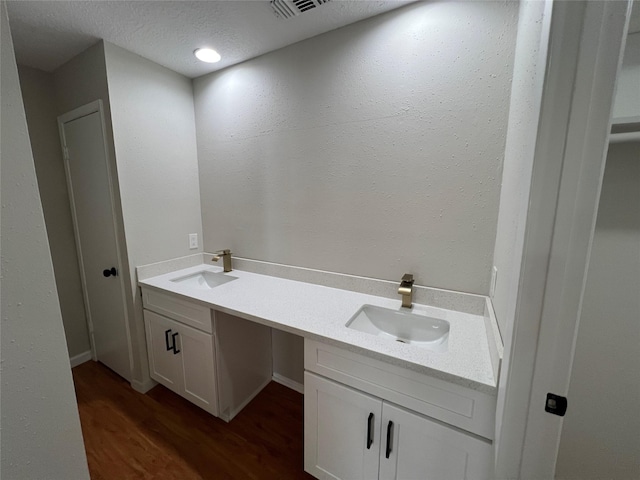 bathroom featuring vanity, wood-type flooring, and a textured ceiling