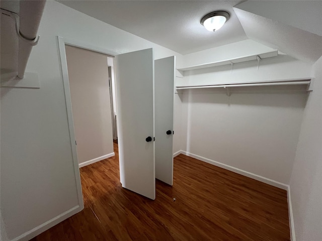 walk in closet with dark wood-type flooring