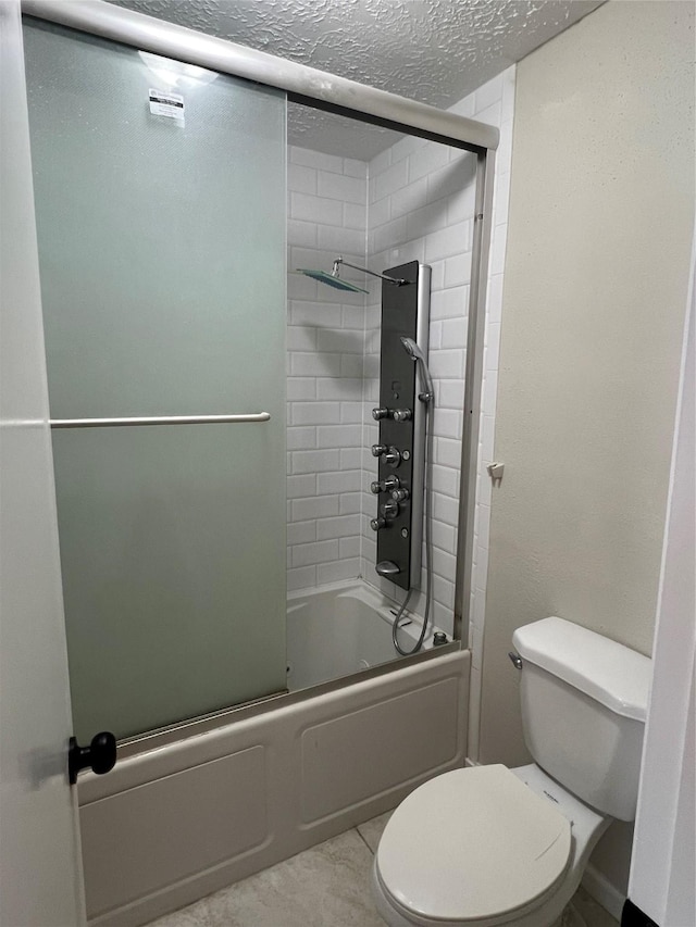 bathroom featuring enclosed tub / shower combo, tile patterned floors, toilet, and a textured ceiling