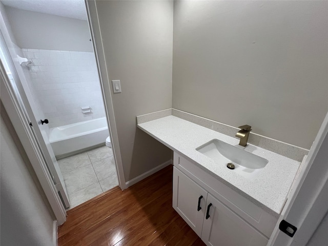 full bathroom with vanity, toilet, hardwood / wood-style floors, and tiled shower / bath