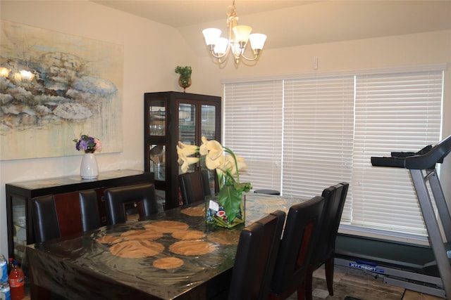 dining space featuring vaulted ceiling and a chandelier