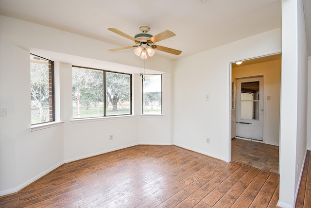 unfurnished room with a ceiling fan, baseboards, and wood finished floors