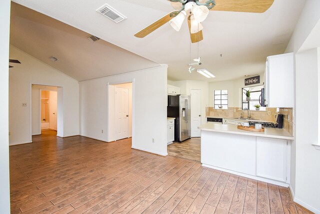 kitchen featuring stainless steel refrigerator with ice dispenser, white cabinetry, kitchen peninsula, and light hardwood / wood-style floors