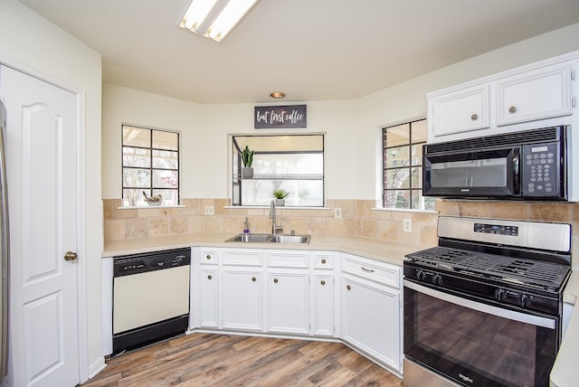 kitchen featuring light countertops, gas stove, white dishwasher, a sink, and black microwave