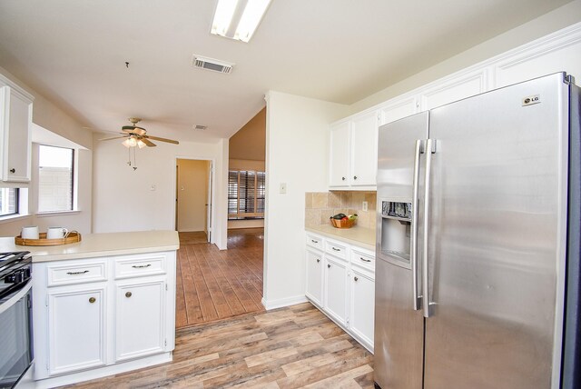 kitchen featuring backsplash, light hardwood / wood-style flooring, white cabinets, and appliances with stainless steel finishes