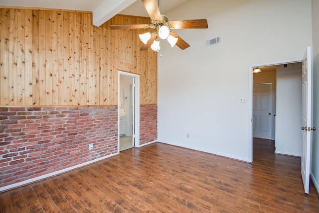 unfurnished room with high vaulted ceiling, brick wall, visible vents, beamed ceiling, and dark wood finished floors