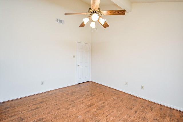 unfurnished room featuring baseboards, visible vents, a ceiling fan, a towering ceiling, and wood finished floors