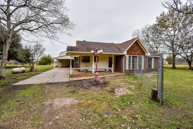 view of front facade with a carport, covered porch, and a front lawn