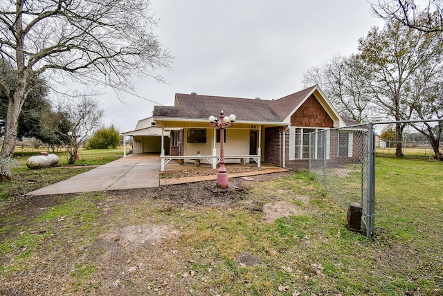 view of front of property with covered porch, brick siding, concrete driveway, a carport, and a front yard