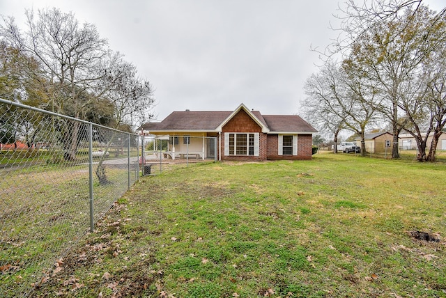 view of front facade featuring brick siding, a front yard, and fence