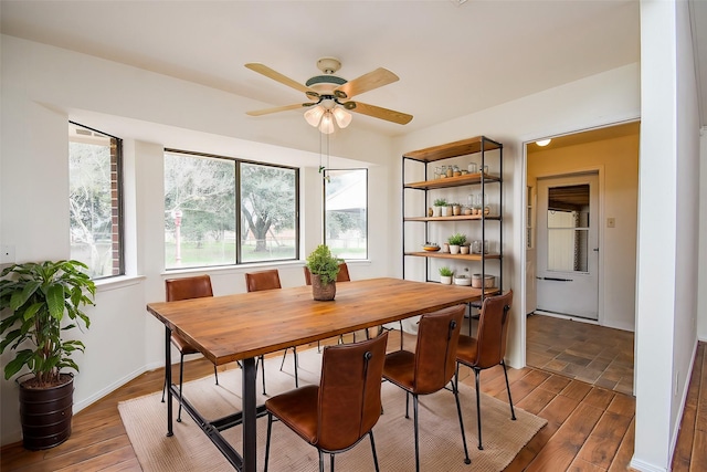 dining room featuring baseboards, dark wood finished floors, and a ceiling fan