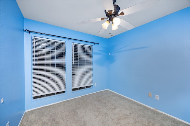 carpeted spare room featuring ceiling fan