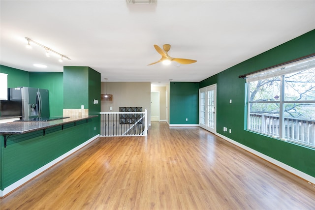 unfurnished living room with light hardwood / wood-style floors and ceiling fan