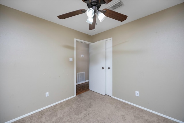 unfurnished room with light colored carpet and ceiling fan