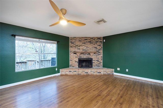 unfurnished living room with hardwood / wood-style flooring, ceiling fan, and a fireplace