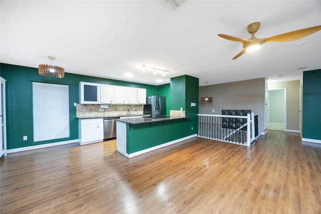 kitchen featuring white cabinetry, tasteful backsplash, kitchen peninsula, pendant lighting, and stainless steel appliances