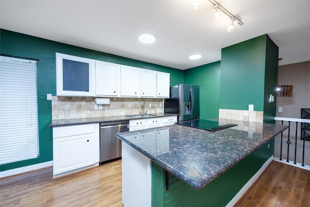 kitchen with stainless steel appliances, white cabinets, a kitchen breakfast bar, and light hardwood / wood-style flooring