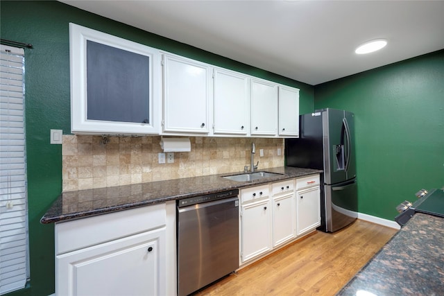 kitchen featuring sink, tasteful backsplash, light wood-type flooring, stainless steel appliances, and white cabinets