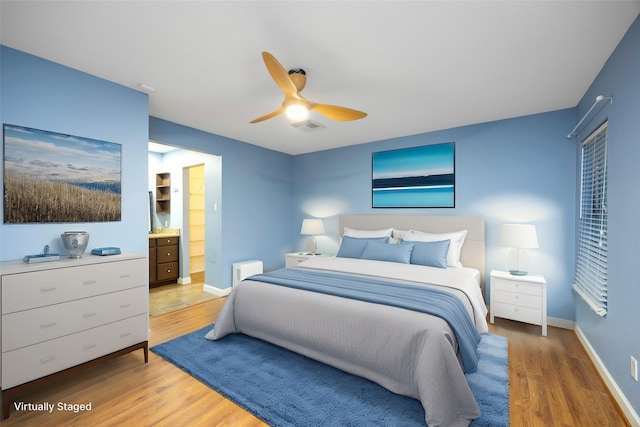 bedroom with hardwood / wood-style flooring, connected bathroom, and ceiling fan