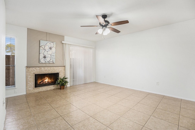 unfurnished living room featuring a tile fireplace, light tile patterned floors, and ceiling fan