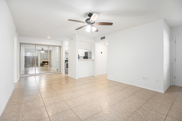 unfurnished living room with ceiling fan and light tile patterned floors