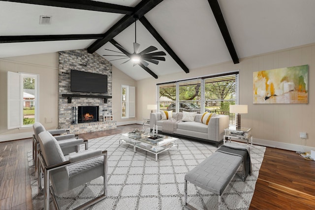 living room featuring hardwood / wood-style flooring, ceiling fan, a fireplace, and vaulted ceiling with beams