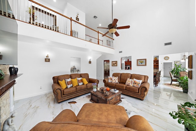 living room featuring a towering ceiling and ceiling fan