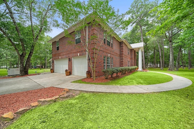 view of side of home featuring a yard, a garage, and central AC unit