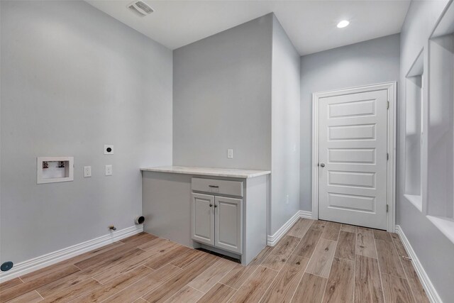 clothes washing area with cabinets, hookup for an electric dryer, and hookup for a washing machine