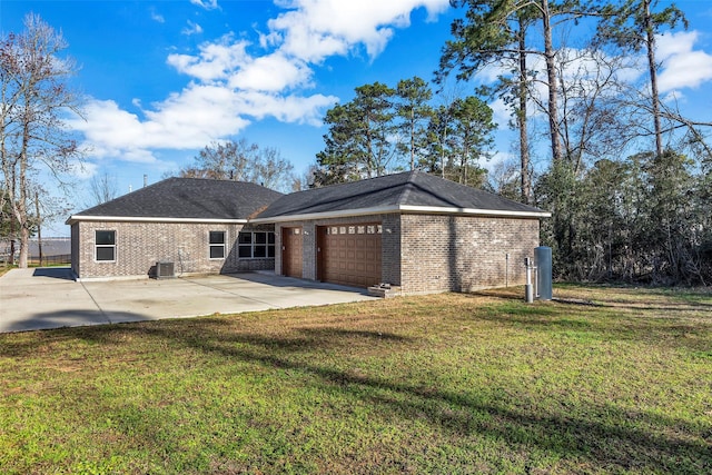 rear view of property with a garage, a yard, central AC unit, and a patio