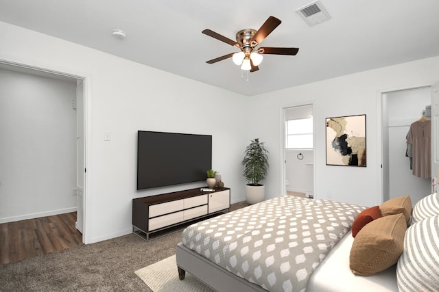 bedroom with ceiling fan, ensuite bathroom, a spacious closet, and carpet floors