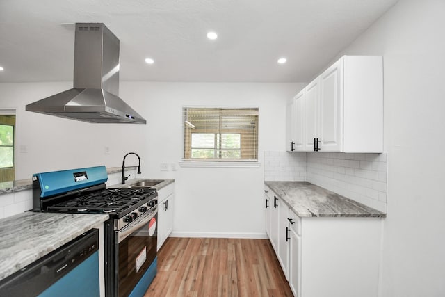 kitchen featuring sink, white cabinetry, appliances with stainless steel finishes, island exhaust hood, and backsplash