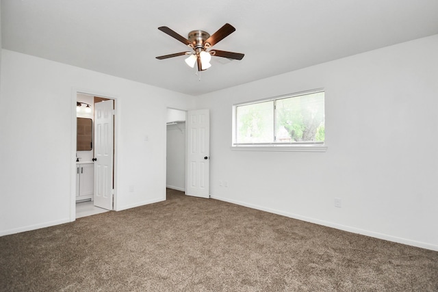 unfurnished bedroom with ceiling fan, carpet floors, ensuite bath, and a closet