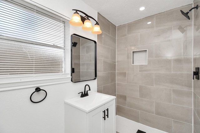 bathroom with vanity and a tile shower