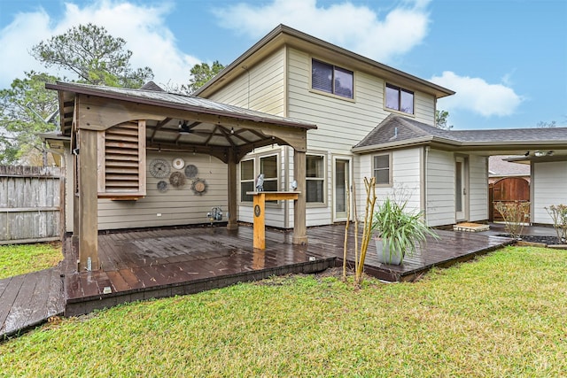 back of house with a deck and a lawn