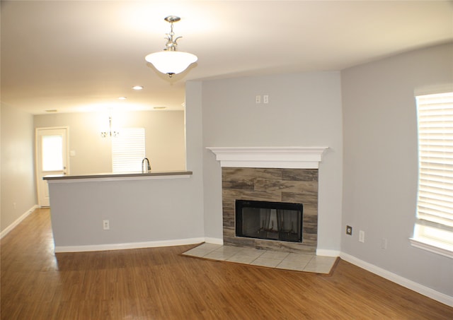 unfurnished living room with sink, a fireplace, and light hardwood / wood-style flooring