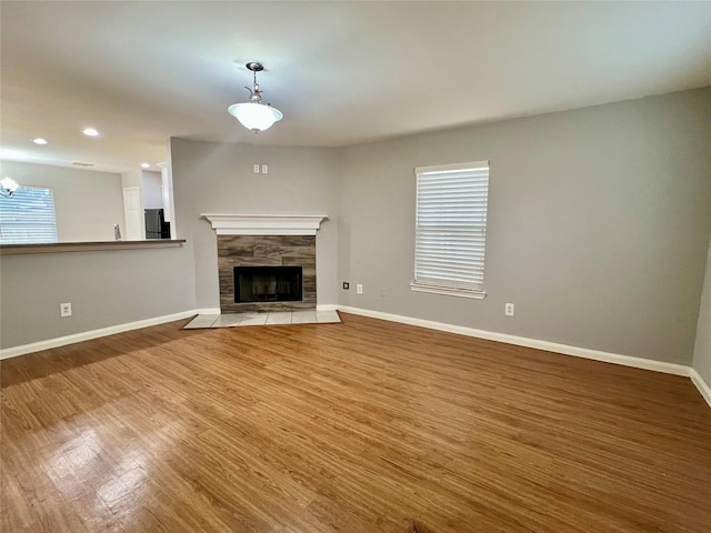 unfurnished living room featuring a fireplace, light wood-style flooring, and baseboards