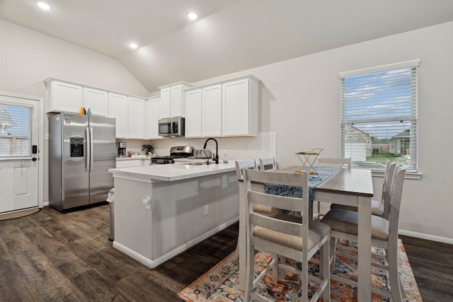 kitchen with white cabinets, appliances with stainless steel finishes, sink, and lofted ceiling